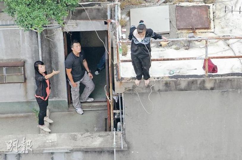患抑鬱症的泰裔婦人(右)昨晨走到住所11樓天台,以電線纏頸兼攀越欄杆企圖「笨豬跳」式跳樓。警方及談判專家到場游說近兩小時,勸服她自行返回安全位置。(鍾炳然攝) 患抑鬱症的泰裔婦人(右)昨晨走到住所11樓天台,以電線纏頸兼攀越欄杆企圖「笨豬跳」式跳樓。警方及談判專家到場游說近兩小時,勸服她自行返回安全位置。(鍾炳然攝)