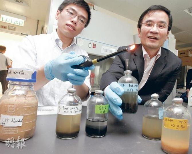 城大實驗人員將廚餘放入儲有細菌群組的器皿內,成功分解出甲烷。主責研究的教授李鈞瀚(左)指用火點燃可見到藍色火焰,證明燃料純淨較少雜質。右為城大能源及環境學院院長陳仲良。(李紹昌攝) 城大實驗人員將廚餘放入儲有細菌群組的器皿內,成功分解出甲烷。主責研究的教授李鈞瀚(左)指用火點燃可見到藍色火焰,證明燃料純淨較少雜質。右為城大能源及環境學院院長陳仲良。(李紹昌攝)