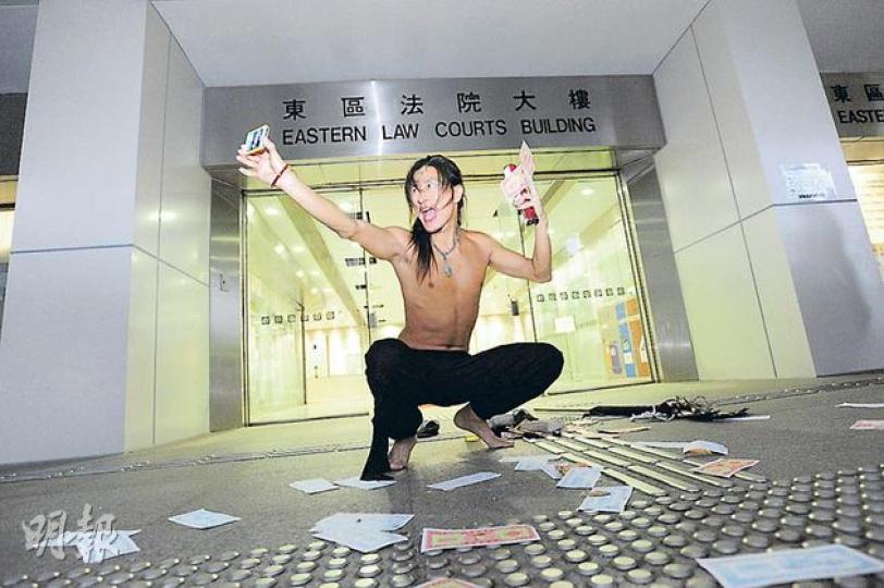 維園霆鋒林克霖涉非禮女模特兒受審,保釋外出後在法院外灑溪錢展示「法寶」,及後被警察驅趕離去。(鄧宗弘攝) 維園霆鋒林克霖涉非禮女模特兒受審,保釋外出後在法院外灑溪錢展示「法寶」,及後被警察驅趕離去。(鄧宗弘攝)