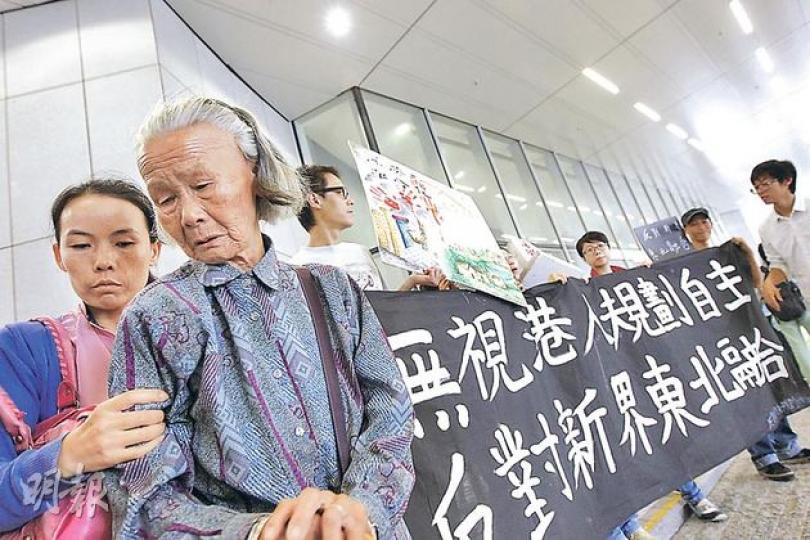 立法會發展事務委員會昨日開會討論蓮塘/香園圍口岸其中一項工程撥款，居於受影響的竹園村50多年的鄧婆婆（左二）到場示威，不滿政府因工程影響清拆村落，卻將竹園村劃分南、北兩村，南村不屬村界範圍，13戶村民最多只獲賠償60萬元，無法受惠政府的「平房方案」。同場亦有反對新界東北規劃組織表達不滿。（李紹昌攝）