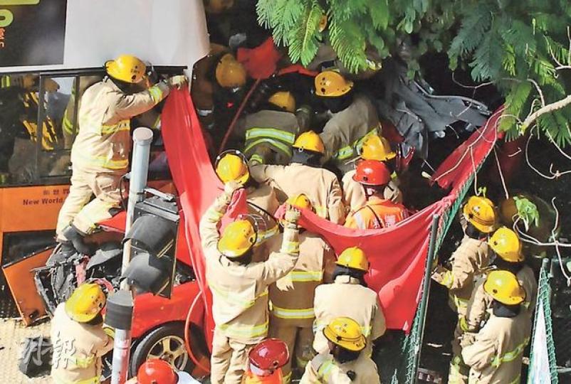 車禍後消防動用逾10人拉起紅布，遮擋拯救過程和傷者，令記者難以拍攝救人情况，記協質疑此舉有損公眾知情權。（鍾炳然攝）