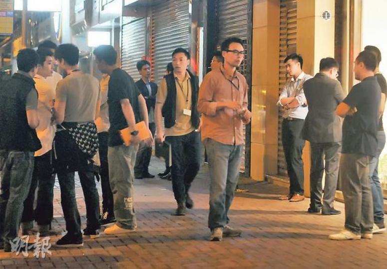 灣仔一間牽涉倫敦金買賣的投資公司兩名股東疑內訌，前晚深夜其中一股東帶同數十人欲從辦公室取走10多袋文件及電腦，但被另一股東召眾阻止，街頭一度有近百人對峙，多名警員及反黑組探員到場控制場面。（蔡方山攝）