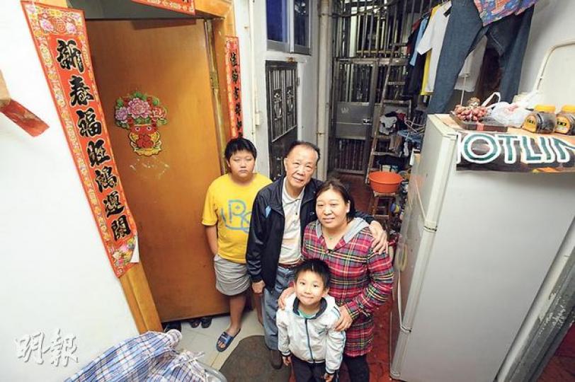 78歲的鍾星（左二）與30餘歲妻子及兩名年幼兒子，同住巷內一房間，鍾叔表示自己早年家境富裕，但數年前生意失敗蝕光家產，故無處可搬，若不獲單位安置，他誓死不遷。（尹錦恩攝）土瓜灣僑裕大樓（左）旁邊的「僭建巷」內數十戶居民，早前被屋宇署入稟要求清拆，現已只剩下6戶12人，留下的都是無力搬遷的居民。（尹錦恩攝）