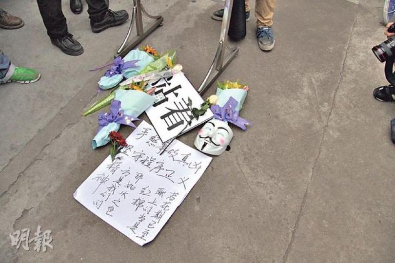 在南方報業集團門口地面,有讀者獻上鮮花和寫着「站着」(意即要員工堅持)字樣的標語。(明報記者攝) 在南方報業集團門口地面,有讀者獻上鮮花和寫着「站着」(意即要員工堅持)字樣的標語。(明報記者攝)