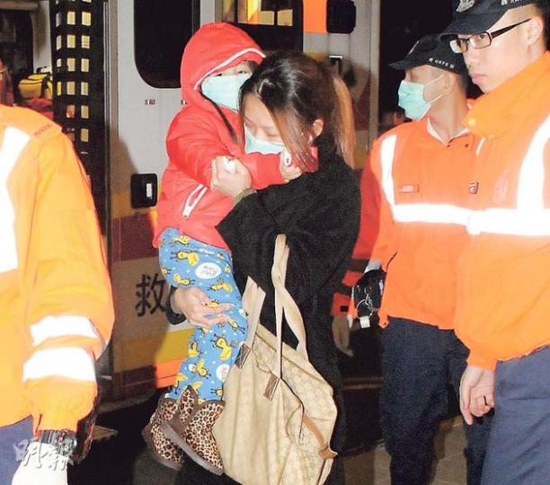 疑被丈夫揮刀指嚇的女子,事後受驚及報稱頭痛,抱着女兒一同送往瑪嘉烈醫院。(蔡方山攝) 疑被丈夫揮刀指嚇的女子,事後受驚及報稱頭痛,抱着女兒一同送往瑪嘉烈醫院。(蔡方山攝)