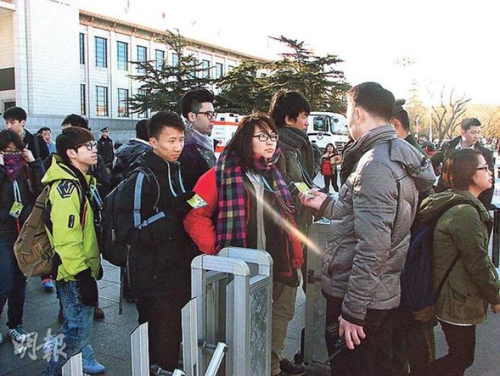 記者一早到廣場外等候，等候大半個小時終可入場。圖為入場時工作人員檢查記者證件。（明報記者攝）