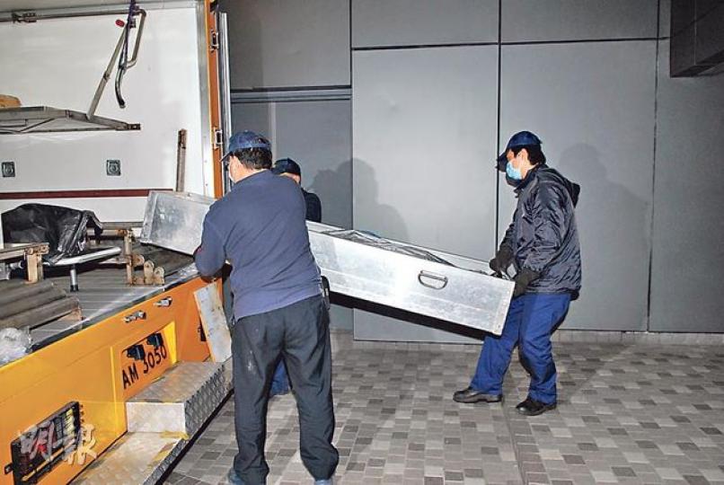 馬鞍山官坑村3個月大男嬰昨凌晨猝死牀上，屍體由仵工舁走。（伍浦鋒攝）男嬰母親（紅衣）一度被警方以涉嫌疏忽照顧兒童為由拘捕，至晚上無條件釋放。（鍾炳然攝）