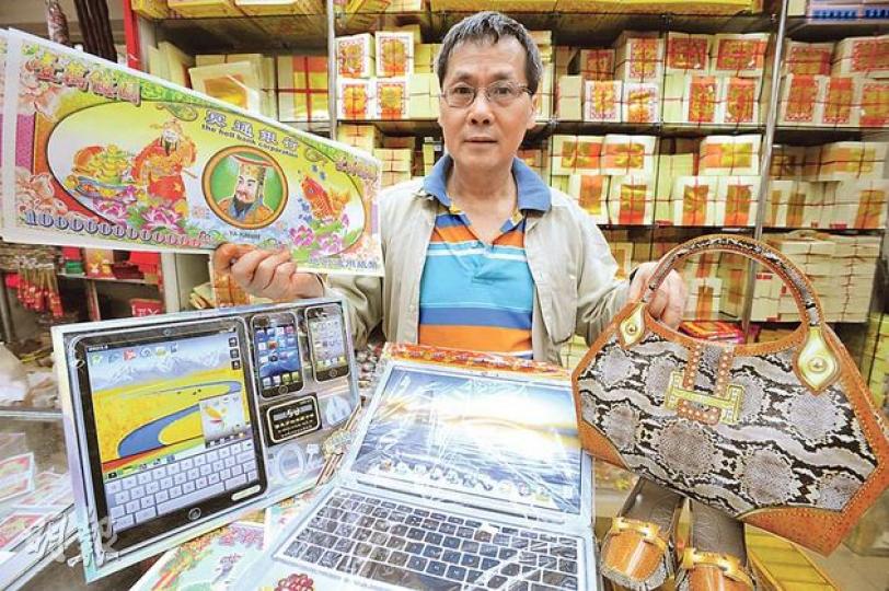 紙紮店俊城行負責人杜千送手中的冥鈔面額高達1萬億元,售價較其他面額貴約1倍,一疊20張售5元。他又稱,近日只敢出售普通款式的手袋(右),疑似名牌的全數收起。(尹錦恩攝) 紙紮店俊城行負責人杜千送手中的冥鈔面額高達1萬億元,售價較其他面額貴約1倍,一疊20張售5元。他又稱,近日只敢出售普通款式的手袋(右),疑似名牌的全數收起。(尹錦恩攝)