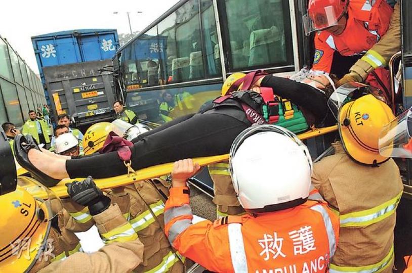 龍翔道近畢架山花園一輛接載大批長者旅遊巴昨失控撞向貨車車尾,20名長者及幼童乘客受傷被困,部分較重傷者,要由消防員用擔架牀協助下由車尾太平門抬出送院。(蔡方山攝) 龍翔道近畢架山花園一輛接載大批長者旅遊巴昨失控撞向貨車車尾,20名長者及幼童乘客受傷被困,部分較重傷者,要由消防員用擔架牀協助下由車尾太平門抬出送院。(蔡方山攝)