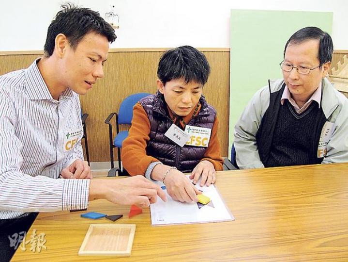 患嚴重腦退化症的李太(中)在丈夫(右)陪同下,由中心經理陳汝威(左)指導重複將七巧板放在適當圖案上,以訓練其記憶和學習能力。(莫凱琳攝) 患嚴重腦退化症的李太(中)在丈夫(右)陪同下,由中心經理陳汝威(左)指導重複將七巧板放在適當圖案上,以訓練其記憶和學習能力。(莫凱琳攝)