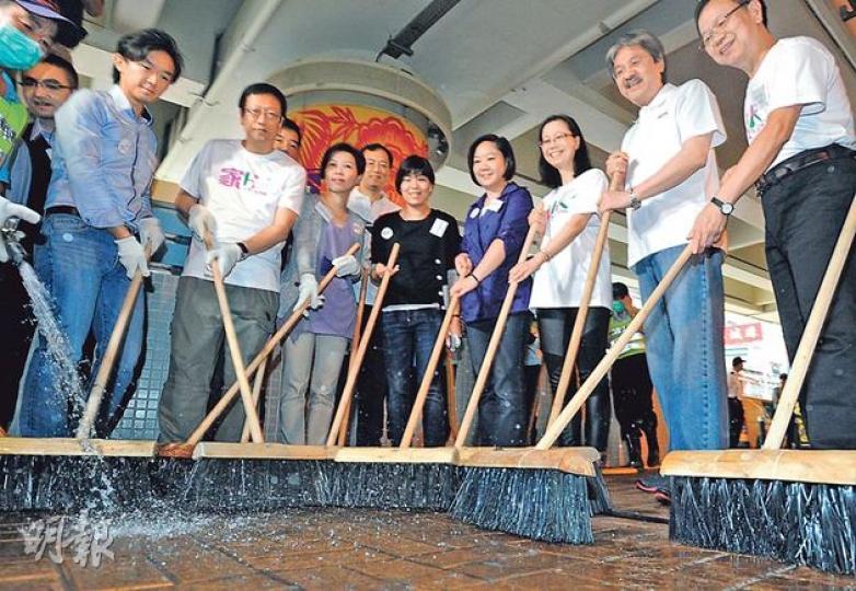 財政司長曾俊華（右二）昨日出席全城清潔運動，在灣仔洗街。他指摘議員「拉布」令整個立法會程序癱瘓，希望有關議員適可而止。（尹錦恩攝）
