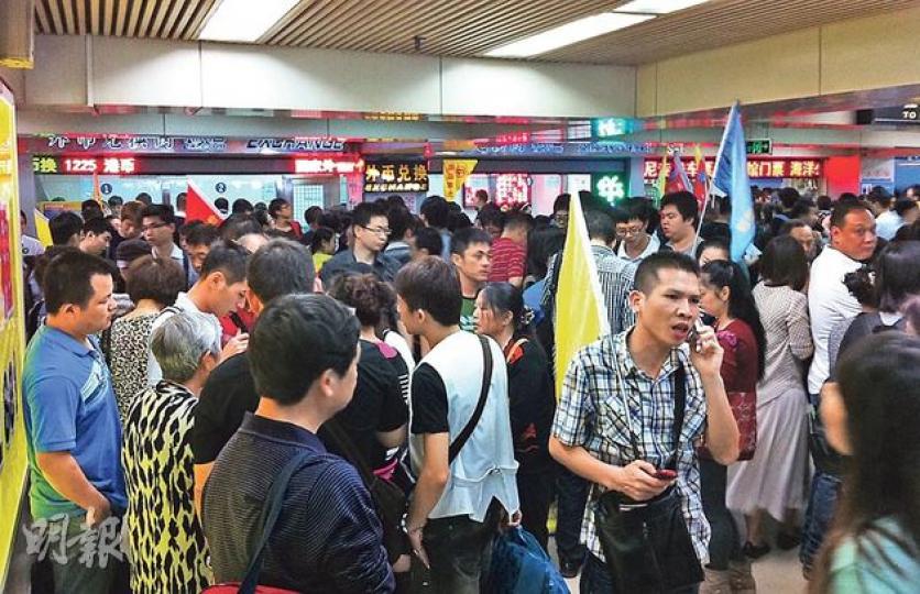 皇崗口岸內昨早湧現大批準備來港的內地旅行團，人流擠滿了關口，旅行團領隊所持的旗幟隨處可見。（李澤彤攝）
