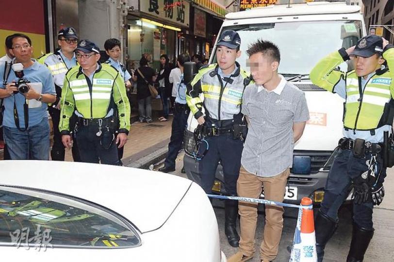 涉嫌毒後駕駛及藏毒被捕的男子（前排灰衣者）被警員押回車輛搜查。由於車尾箱無法打開，擾攘近兩小時後，警方將車輛拖回警署。（蔡方山攝）