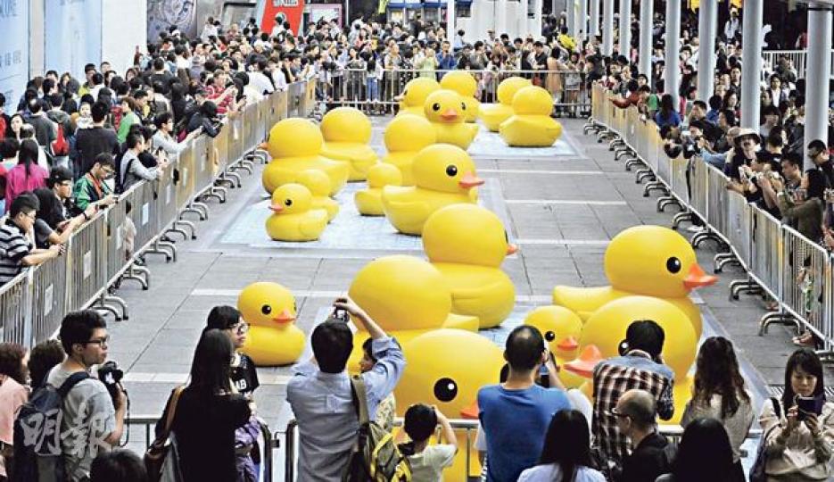 24隻同樣可愛的「鴨兄弟」率先在海運大廈露天廣場「着陸」，並在以3D技術製作的「水池」嬉戲，吸引數百市民及遊客駐足拍照。（劉焌陶攝）早前試水後被「放氣」的巨鴨昨晚7時前已運抵尖沙嘴海運碼頭，有前來「追鴨」市民形容，其扁了的模樣似足救生圈及鴨餅，但鮮艷的黃色仍十分搶眼，「臘鴨」在深宵時分開始「吹脹」，今日起正式亮相。（劉焌陶攝）海港城同步舉行「橡皮鴨」寫真展，展出鴨仔遊世界的照片，並設有一個「大浴池」滿載逾千隻小膠鴨，昨日已有不少人前往拍照。（劉焌陶攝）
