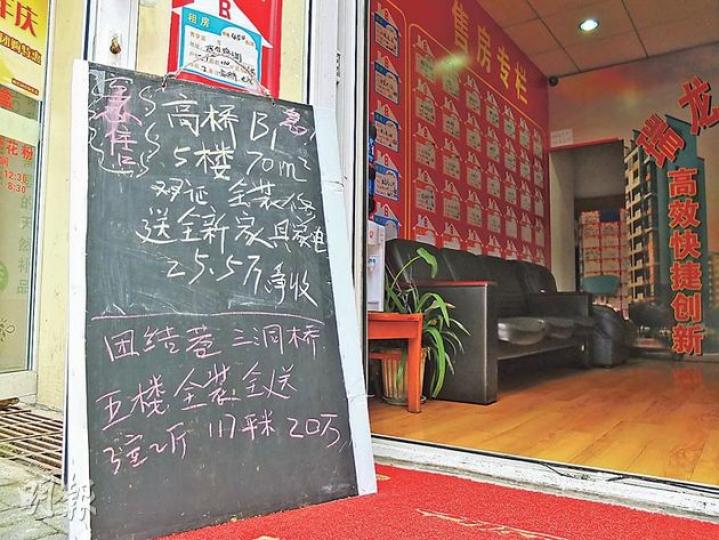 都江堰樓市低迷，有地產中介用黑板寫出的急售單位，價格低廉。（許書凎攝）
