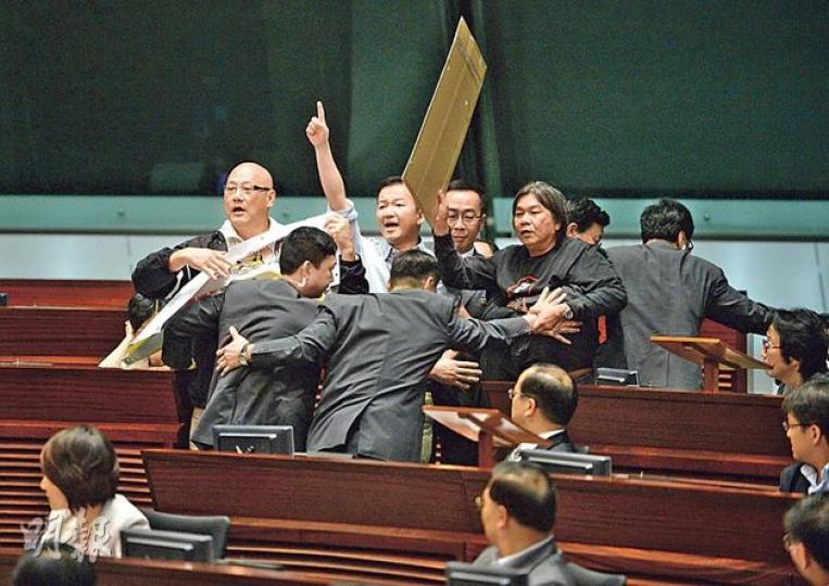 特首梁振英在答問大會開場白中特別批評拉布行動，4名拉布議員包括社民連梁國雄（舉牌者）、人民力量陳志全（舉手者）、陳偉業（後左）及黃毓民隨即高呼抗議，最終被主席曾鈺成趕出會議廳。（盧翊銘攝）