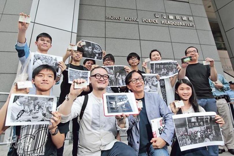 警方事隔22個月拘捕佔中義工陳玉峰,並說已通緝陳多時,引發11名去年反國民教育科集會人士,包括張秀賢(前排左起)、邵家臻、韓連山、黃莉莉等昨日帶同參與反國教科的照片,到警察總部「投案」,查詢自己是否在低調通緝的名單上。圖後排左起為黎汶洛、陳樹暉、蕭超杰、林朗彥、黃之鋒、葉寶琳及陳景輝。(郭慶輝攝)11名反國教科集會核心成員昨日事先張揚「投案」,警方如臨大敵,在灣仔警察總部外佈滿鐵馬,每個門口均有多名軍裝警員把守,多名警長亦在場監視。(郭慶輝攝) 警方事隔22個月拘捕佔中義工陳玉峰,並說已通緝陳多時,引發11名去年反國民教育科集會人士,包括張秀賢(前排左起)、邵家臻、韓連山、黃莉莉等昨日帶同參與反國教科的照片,到警察總部「投案」,查詢自己是否在低調通緝的名單上。圖後排左起為黎汶洛、陳樹暉、蕭超杰、林朗彥、黃之鋒、葉寶琳及陳景輝。(郭慶輝攝)11名反國教科集會核心成員昨日事先張揚「投案」,警方如臨大敵,在灣仔警察總部外佈滿鐵馬,每個門口均有多名軍裝警員把守,多名警長亦在場監視。(郭慶輝攝)
