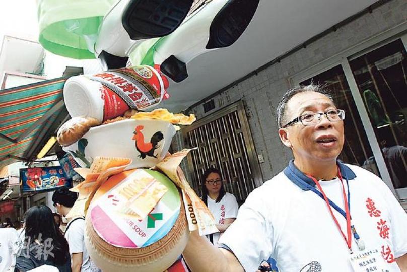 長洲飄色架師傳黃成就表示，告別作「貪湯」飄色用的海味乾貨道具是街坊送贈的退休禮物。（李紹昌攝）