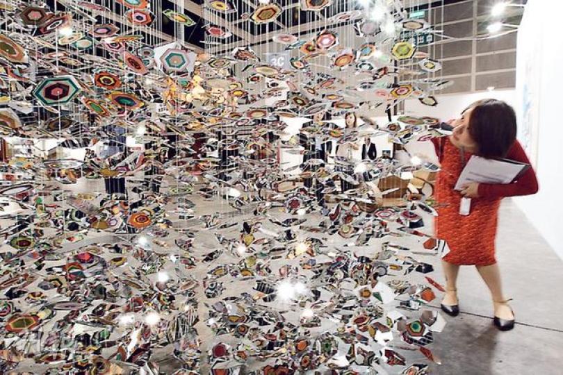 呢件由美國洛杉磯藝術家Pae White設計嘅展品，用魚絲吊住2000塊「兩面玻璃」，再喺玻璃一邊貼上顏色紙，營造出七彩繽紛嘅視覺效果，唔少入場人士都覺得好靚。（李紹昌攝）日本藝術家Aida Makoto（會田誠）作品《飯團假面》，係13年以來喺佢作品中出現嘅另一個自我形象，突顯惰性、土裏土氣等。（李紹昌攝）噚日臨時多咗一件「新展品」，呢隻小麻雀因為「避雨」入咗會展躲避，眼仔碌碌周圍睇，畫廊負責人就話可以暫時畀雀仔休息吓。（李紹昌攝）