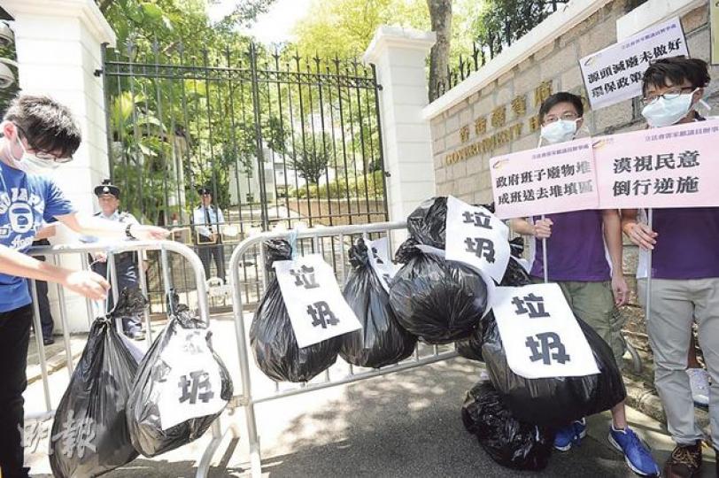 10多名公民黨成員昨由中環皇后像廣場遊行到禮賓府，不滿政府在沒有長遠的環保政策下強推屯門堆填區方案，並不滿行政長官梁振英沒有落區聽取屯門居民的意見，要求政府撤回方案，他們戴上口罩，把數袋垃圾掛在鐵馬上，遞交請願信後離開。（尹錦恩攝）