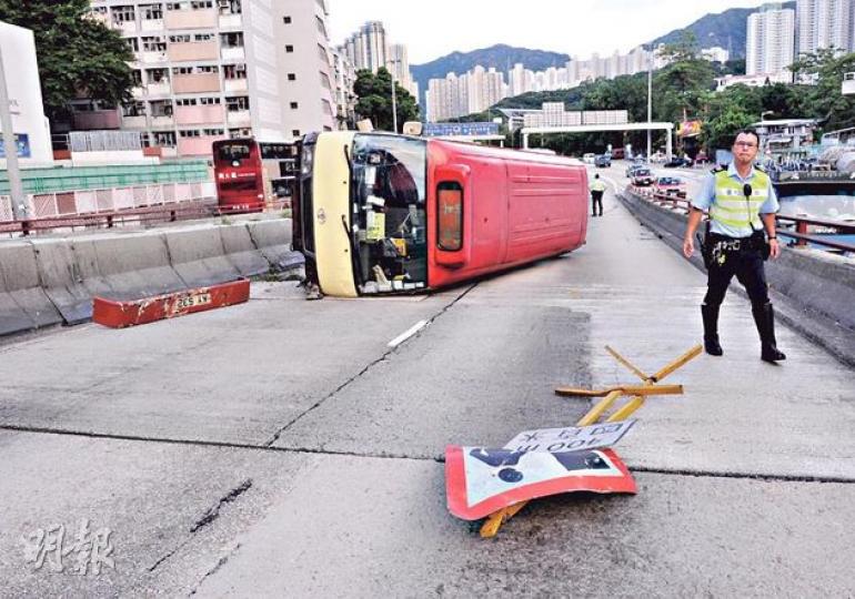 紅色小巴疑閃避切線私家車時失控剷上如跳台般的分隔石壆，以單邊車輪滑行約40米後在橋上翻側，車頭泵把脫落，一個路面維修指示牌也被撞跌。（蔡方山攝）