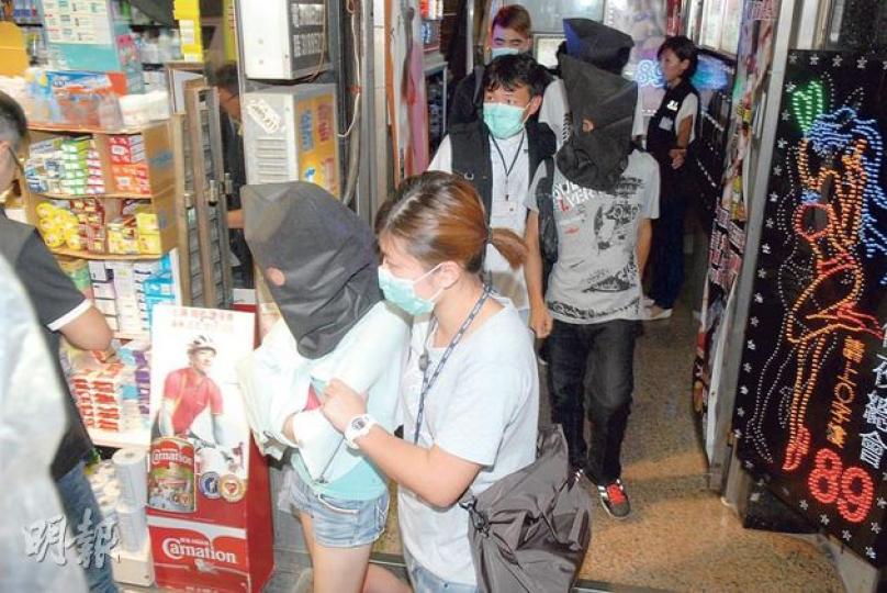警方持續採取代號「保苗」反黑及掃毒行動，昨晚在砵蘭街211號一賓館房間拘捕的4名涉販毒男女，將他們黑布蒙頭帶署扣查。（伍浦鋒攝）警方展示在「保苗」行動中檢獲的毒品。（伍浦鋒攝）