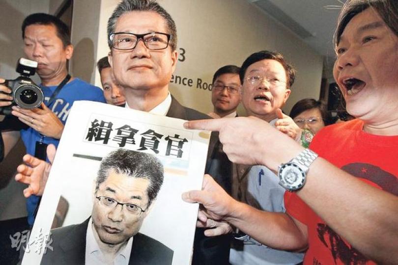 發展局長陳茂波(前左)昨到立法會出席發展事務委員會特別會議時,社民連立法會議員梁國雄(右)向他遞上「緝拿貪官」的海報,要他下台。(李紹昌攝) 發展局長陳茂波(前左)昨到立法會出席發展事務委員會特別會議時,社民連立法會議員梁國雄(右)向他遞上「緝拿貪官」的海報,要他下台。(李紹昌攝)