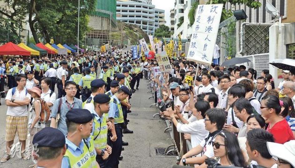 特首梁振英第二周落區，論壇舉行地點觀塘功樂官立中學場外的功樂道，數百名反梁者抗議（右），過百名警員則排成一字阻止他們衝出馬路或衝擊對面會場。（余俊亮攝）泛民主派發起默站行動，以不喊口號、不與他人對罵方式，在學校門外向梁振英抗議。前排右起為民主黨林卓廷、教協韓連山、公民黨余若薇、社民連吳文遠、公民黨梁家傑等。（盧翊銘攝）
