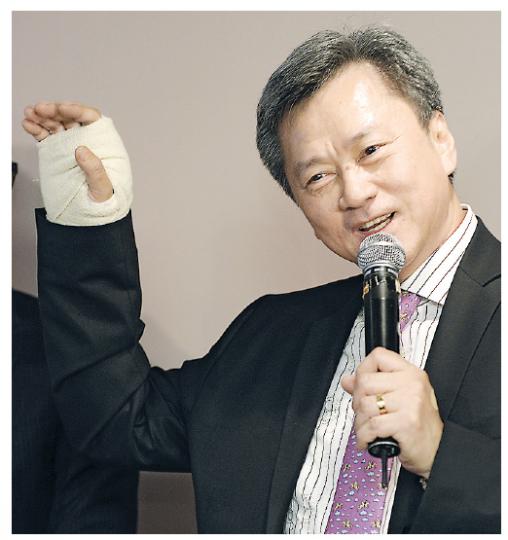 早前以手傷為由缺席置富產業信託業績會的趙國雄，昨日帶傷出席長實新成立的Club Lifestyle記者會，高舉「傷手」表示已無大礙之餘，更自稱「招財貓」。（余俊亮攝）