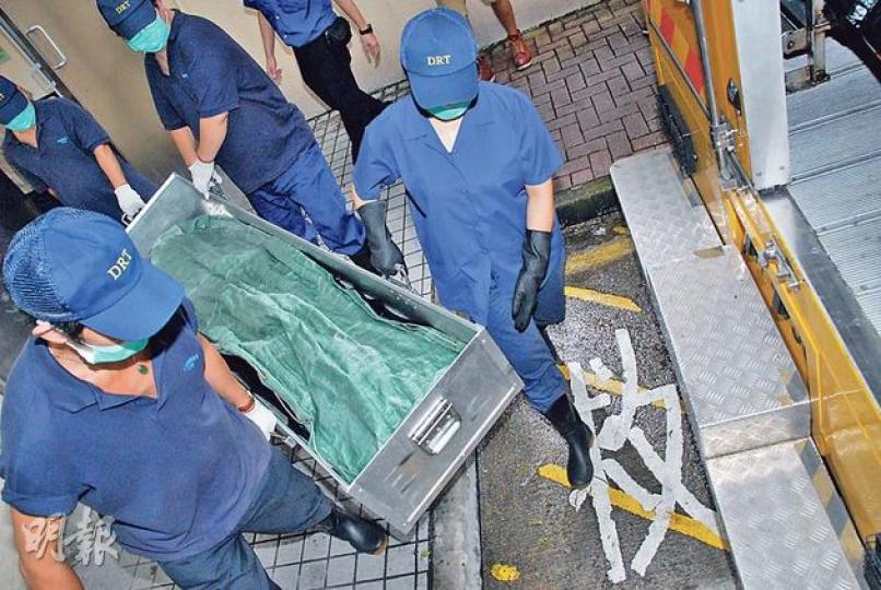 與母同牀不幸昏迷死亡的兩月大男嬰，遺體由仵工舁送殮房，待法醫驗證死因。（雲錦鋒攝）