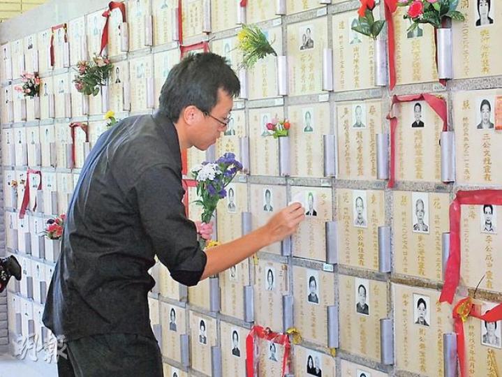 菲律賓人質事件3周年，謝廷駿的家屬到鑽石山墳場拜祭，弟弟謝志恆獻上鮮花並將龕位上的灰塵抹走。（周翠怡攝）