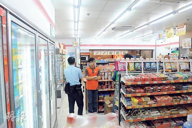警員在遇劫便利店調查，向職員了解案發經過。（蔡方山攝）