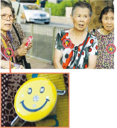 不少排隊的長者身上都掛上左圖黃色的「哈哈笑」襟章(上圖紅圈示),但他們拒透露是什麼組織動員而來。(明報記者攝)民建聯南區區議員楊位款(左),昨下午在禮頓山社區會堂附近停車場現身。被問到有旅遊巴士接載長者來排隊拿特首論壇門券,他只說有很多街坊是自行前來。(明報記者攝)社區會堂外,有人用「愛秩序灣居民協會」的膠椅排隊。愛秩序灣區議員、民建聯顏尊廉否認有動員,反問記者「這麼奇怪,不知是否有人拿了過去?」(明報記者攝) 不少排隊的長者身上都掛上左圖黃色的「哈哈笑」襟章(上圖紅圈示),但他們拒透露是什麼組織動員而來。(明報記者攝)民建聯南區區議員楊位款(左),昨下午在禮頓山社區會堂附近停車場現身。被問到有旅遊巴士接載長者來排隊拿特首論壇門券,他只說有很多街坊是自行前來。(明報記者攝)社區會堂外,有人用「愛秩序灣居民協會」的膠椅排隊。愛秩序灣區議員、民建聯顏尊廉否認有動員,反問記者「這麼奇怪,不知是否有人拿了過去?」(明報記者攝)