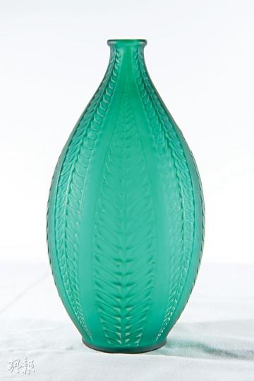 Acacia花瓶(1921年作品)﹕少有鮮色的René Lalique玻璃作品,1947年停產,直至近年才重新推出,但已改為清水晶及紅水晶(分別售$7300及$8500)。Acacia瓶身是金合歡樹的樹葉圖案,金合歡樹象徵生命不朽和神秘知識。李少傑1990年代在巴黎購入,當時購入價約為20萬港元。(黃志東攝)Lalique香水瓶Petites feuilles(1910作品)﹕René Lalique於1905年首先為COTY設計香水瓶。李少傑認為,要收藏Lalique便一定要有一件香水瓶,因為 Acacia花瓶(1921年作品)﹕少有鮮色的René Lalique玻璃作品,1947年停產,直至近年才重新推出,但已改為清水晶及紅水晶(分別售$7300及$8500)。Acacia瓶身是金合歡樹的樹葉圖案,金合歡樹象徵生命不朽和神秘知識。李少傑1990年代在巴黎購入,當時購入價約為20萬港元。(黃志東攝)Lalique香水瓶Petites feuilles(1910作品)﹕René Lalique於1905年首先為COTY設計香水瓶。李少傑認為,要收藏Lalique便一定要有一件香水瓶,因為