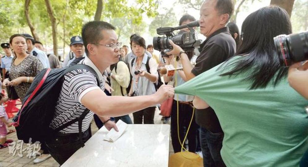 原定今日派發1000份入學申請表的上水惠州幼稚園，昨午先派500個籌疏導校外人龍，籌迅速派光後，有未能取籌的男子拉扯學校女職員衣袖。他接受訪問時自稱來自內地。（余俊亮攝）