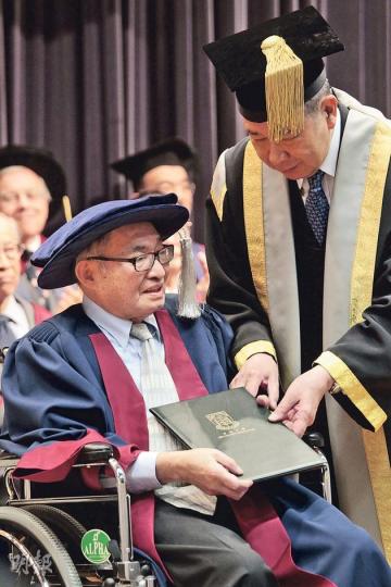 港大學生會前辦公室經理呂君發「發叔」(左前)獲頒港大名譽大學院士,他昨以輪椅代步,在港大副校監李國寶手上接過證書。全場師生鼓掌近1分鐘向發叔致意。(郭慶輝攝) 港大學生會前辦公室經理呂君發「發叔」(左前)獲頒港大名譽大學院士,他昨以輪椅代步,在港大副校監李國寶手上接過證書。全場師生鼓掌近1分鐘向發叔致意。(郭慶輝攝)