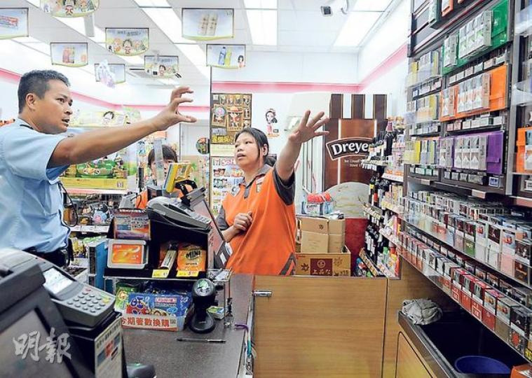 觀塘輔仁街10號遇劫便利店的女職員,向警員講述案發經過。(蔡方山攝) 觀塘輔仁街10號遇劫便利店的女職員,向警員講述案發經過。(蔡方山攝)