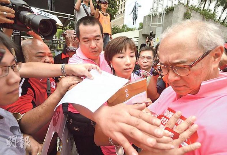 社民連10多名成員昨趁港鐵在中環舉行競步賽請願,抗議港鐵連年在有巨額盈利下加價,其間港鐵主席錢果豐(右一)走近示威者時,有社民連成員(左一)向他貼上「港鐵加價,貪得無厭」的抗議標語,並在現場撒溪錢,在場的港鐵項目傳訊經理陳芳婷(右二)馬上撕走貼紙,並有港鐵職員阻止示威者靠近。(余俊亮攝) 社民連10多名成員昨趁港鐵在中環舉行競步賽請願,抗議港鐵連年在有巨額盈利下加價,其間港鐵主席錢果豐(右一)走近示威者時,有社民連成員(左一)向他貼上「港鐵加價,貪得無厭」的抗議標語,並在現場撒溪錢,在場的港鐵項目傳訊經理陳芳婷(右二)馬上撕走貼紙,並有港鐵職員阻止示威者靠近。(余俊亮攝)