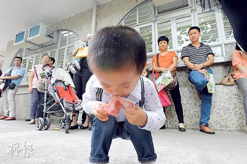 昨日惠州幼稚園門外,有大批家長和小童輪候,等候面試期間,有小童把玩手中的人民幣100元鈔票,更把紙幣放入口中。(李紹昌攝) 昨日惠州幼稚園門外,有大批家長和小童輪候,等候面試期間,有小童把玩手中的人民幣100元鈔票,更把紙幣放入口中。(李紹昌攝)