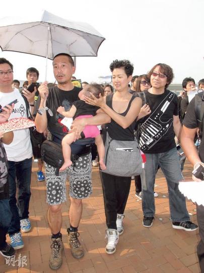 現仍為無綫合約藝人的陳國邦(右三)昨午一手撐傘,一手抱起女兒,與妻子羅敏莊(右二)一齊參與遊行,他批評政府以無先例為由,拒絕交代行會不發牌予港視的原因,令他感到憤怒,又說自己「驚政府多過驚TVB」,不擔心會被公司秋後算帳。(林祖傑攝)剛約滿港視的演員余慕蓮昨日戴上太陽眼鏡參與遊行,她認為政府拒絕發牌予香港電視,會減低業界競爭,影響演員生計。(孫華中攝)公務員事務局前局長王永平昨參加遊行,他認為今次政府的發牌決定違反普羅市民認識的公義,令許多政治冷感的市民都感到憤怒。(郭慶輝攝) 現仍為無綫合約藝人的陳國邦(右三)昨午一手撐傘,一手抱起女兒,與妻子羅敏莊(右二)一齊參與遊行,他批評政府以無先例為由,拒絕交代行會不發牌予港視的原因,令他感到憤怒,又說自己「驚政府多過驚TVB」,不擔心會被公司秋後算帳。(林祖傑攝)剛約滿港視的演員余慕蓮昨日戴上太陽眼鏡參與遊行,她認為政府拒絕發牌予香港電視,會減低業界競爭,影響演員生計。(孫華中攝)公務員事務局前局長王永平昨參加遊行,他認為今次政府的發牌決定違反普羅市民認識的公義,令許多政治冷感的市民都感到憤怒。(郭慶輝攝)