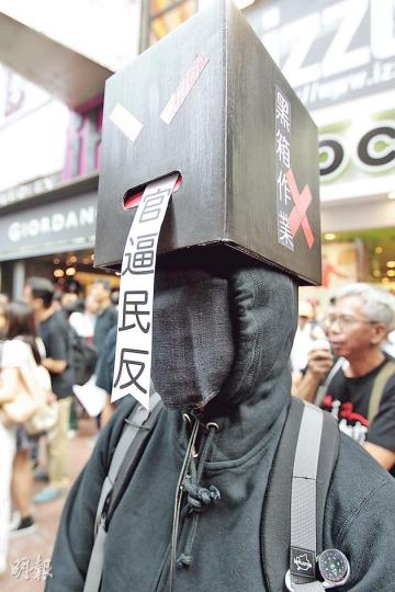有遊行人士頭頂黑箱、身穿黑衣、面蓋黑布，諷刺政府黑箱作業，黑箱的嘴巴還吐出「官逼民反」字條。（郭慶輝攝）亞視主要投資者王征都撐港視？非也，集會中出現的「王征」乃網民悉心打扮的「黃精」。戴上王征面具、手執寫着「否決ATV續牌申請」紙扇的「黃精」說，去年見王征利用公共頻道直播自己舞技「十分嘔心」，啟發他模仿王征，「今次是難得的機會諷刺他」。他口袋中還有一張寫着「中國和諧銀行 維穩費2千萬元」的「支票」，諷刺亞視淪為中央喉舌，「黃精」亦有求必應，即席重演政總前「騷舞技」一幕。（盧翊銘攝）有港視員工自製