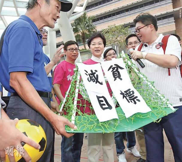 約10名關注綜援低收入聯盟成員帶同道具龍門和足球向政務司長林鄭月娥(中)請願, 促請政府盡快訂立減貧目標和制訂具體政策,並要求改善綜援制度,改善低收入人士生活。(李紹昌攝) 約10名關注綜援低收入聯盟成員帶同道具龍門和足球向政務司長林鄭月娥(中)請願, 促請政府盡快訂立減貧目標和制訂具體政策,並要求改善綜援制度,改善低收入人士生活。(李紹昌攝)