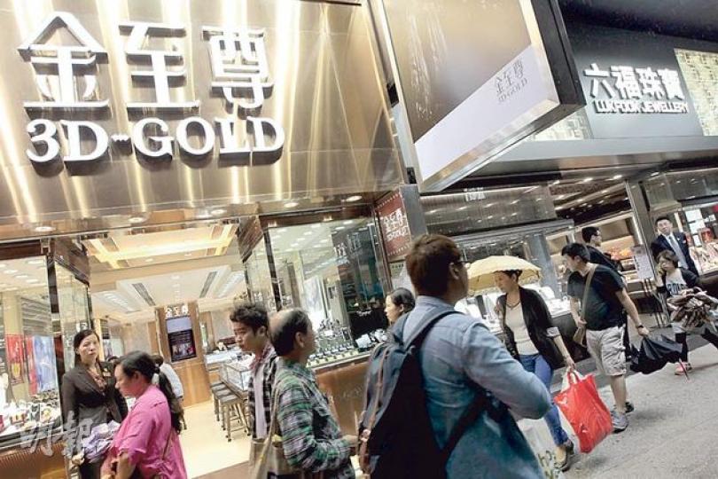 六福及香港資源昨日雙雙停牌，市傳六福擬併購香港資源持有的金至尊業務。圖為金至尊（左）及六福（右）位於香港的分店。（李澤彤攝）