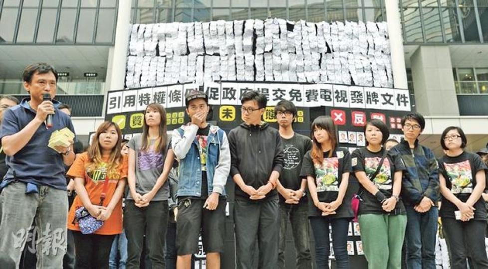 立法會否決引用特權法索取電視發牌文件後，留守政府總部的10名港視前員工代表上台宣讀聲明，港視前導演蔡錦源（左一）指員工留守19天後，現稍作休息和找工作，本月30日晚上8時黑衣為記，到添馬公園辦集思會，歡迎市民帶食物和飲品參與。（余俊亮攝）