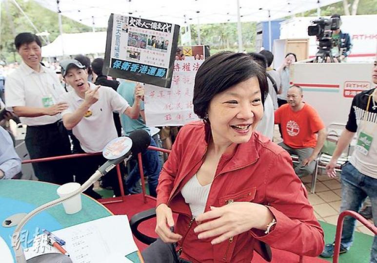 噚日城市論壇討論免費電視，獲邀嘅公民黨余若薇（紅衫）走入維園阿伯同「愛字頭」組織嘅「主場」，自然成狙擊對象。除講嘢時被噓，不時都有人喺後面舉牌抗議。（李澤彤攝）
