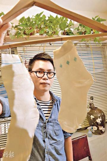 阿Ben在父親離世後一年,將其父白背心、孖煙囪、白襪及人字拖製成「陶瓷故衣」,以作懷念;圖為阿Ben另外製作的陶瓷白襪,並指在陽光照射下,會透出淡淡的光芒。(劉焌陶攝)阿Ben當年製作「陶瓷故衣」,是先將父親的衣物壓在白瓷泥上,令其紋理壓劃在泥土之間,再將兩者一併放入千度火爐燒窰,以保留將故衣火化的傳統。(劉焌陶攝) 阿Ben在父親離世後一年,將其父白背心、孖煙囪、白襪及人字拖製成「陶瓷故衣」,以作懷念;圖為阿Ben另外製作的陶瓷白襪,並指在陽光照射下,會透出淡淡的光芒。(劉焌陶攝)阿Ben當年製作「陶瓷故衣」,是先將父親的衣物壓在白瓷泥上,令其紋理壓劃在泥土之間,再將兩者一併放入千度火爐燒窰,以保留將故衣火化的傳統。(劉焌陶攝)