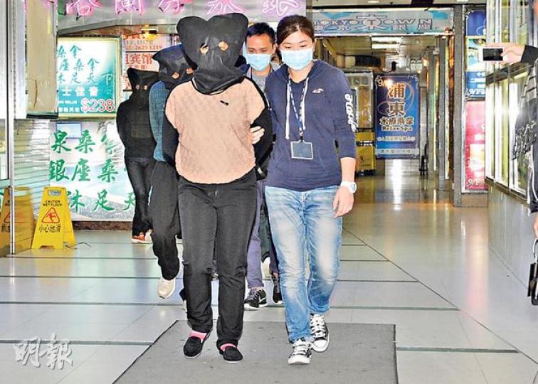 「色誘賊黨」4名內地男女,由警員黑布蒙頭押返警署扣查。(蔡方山攝) 「色誘賊黨」4名內地男女,由警員黑布蒙頭押返警署扣查。(蔡方山攝)