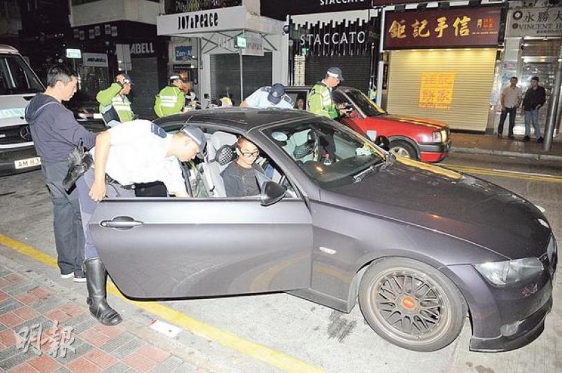 涉停牌期間駕駛的男子,坐在其掛有自訂車牌的寶馬房車接受調查,其後被警方以停牌期間駕駛等3宗罪拘捕。(蔡方山攝) 涉停牌期間駕駛的男子,坐在其掛有自訂車牌的寶馬房車接受調查,其後被警方以停牌期間駕駛等3宗罪拘捕。(蔡方山攝)