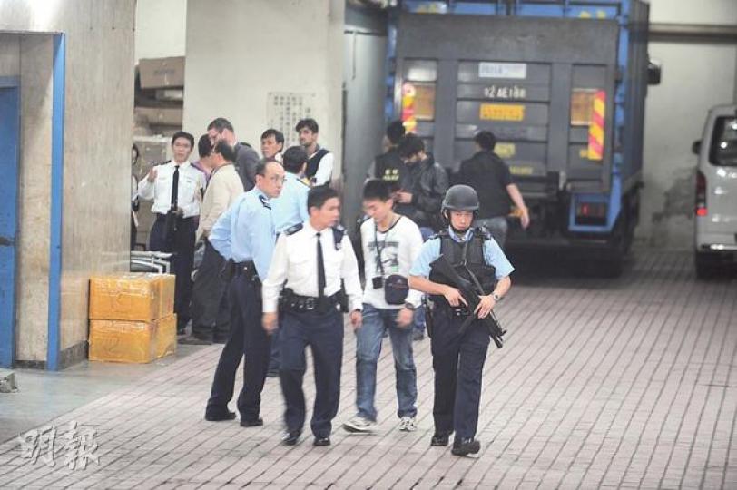 大批警員穿著避彈衣荷槍實彈趕至搜捕刀槍劫徒，惟未有發現。（樊銳昌攝）貨倉負責人（中）於事發後趕返現場了解後，與一度遭匪徒綑綁制服的職員（左）一同隨探員返署助查。（樊銳昌攝）