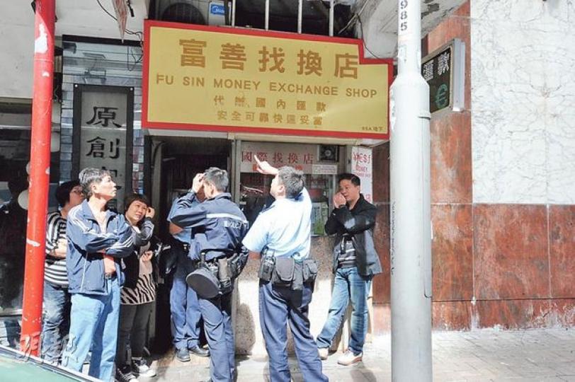 北角一間找換店昨晨被人撬門爆竊，警員到場調查時，找換店上唐樓單位的玻璃掉下，擊中警方私家車車頂，以致輕微凹陷，幸無人受傷。（衛永康攝）
